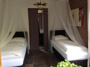 赫鲁斯贝克霍非亚住宿加早餐旅馆的配有2张床的白色床单和窗帘