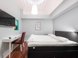 斯德哥尔摩莫斯贝克旅馆的一间卧室配有一张床、一张书桌和一台电视。