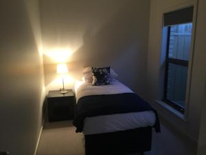 金斯科特金斯科特湾公寓式酒店的一间小卧室,配有床和灯