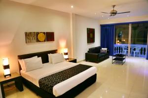 南芭堤雅东方套房酒店的一间卧室设有一张床和一间客厅。