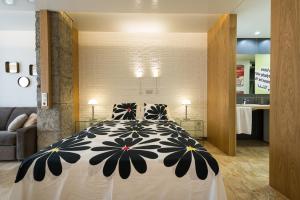 大加那利岛拉斯帕尔马斯Suites Garden Loft Andy Warhol的一间卧室配有一张带黑白色棉被的床