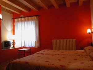 Cabrejas del Pinar斯提阿卡米诺德拉福恩特纳酒店的红色的卧室设有床和窗户