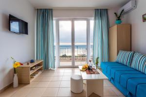 斯韦蒂·斯特凡Blue Mediterranean Apartments的客厅设有蓝色的沙发和大窗户