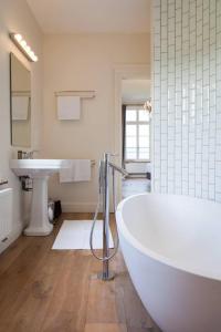 珀潘斯特尔Château Charles的白色的浴室设有浴缸和水槽。