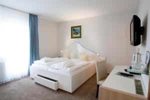 维滕Frühstückshotel Seemannsbraut Amrum-adults only ab 18 Jahre-keine Haustiere-的白色卧室配有白色的床和书桌