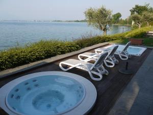 代森扎诺-德尔加达阿卡维瓦戴加尔达酒店的一个带椅子和浴缸的游泳池
