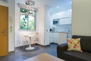 大加那利岛拉斯帕尔马斯Suites Garden Loft Miro的带沙发和桌子的客厅以及厨房。