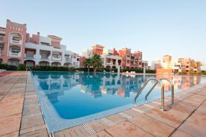 萨伊迪耶Appartement Résidence Alwaha Saidia的一座大型游泳池,其建筑背景为: