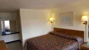 布莱克斯堡布莱克斯堡红毯汽车旅馆的酒店客房,配有一张床和两盏灯