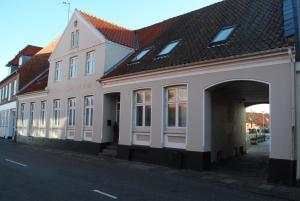 伦讷德特里列酒店的街道上带有拱门的白色建筑