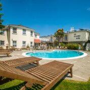 圣马丁格恩西Les Douvres Hotel的一个带野餐桌和长凳的游泳池