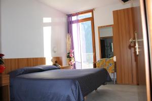 松达洛瑞泽亚酒店的一间卧室设有蓝色的床和窗户。