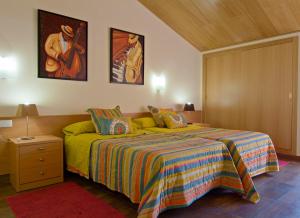 圣科洛马·德法尔品克斯酒店的一间卧室配有一张带彩色毯子的床