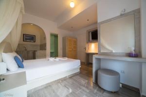 卡马利阿基里斯公寓酒店的卧室配有一张白色大床和镜子