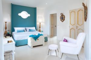 陶尔米纳陶尔米纳别墅酒店的蓝色和白色的卧室,配有床和椅子