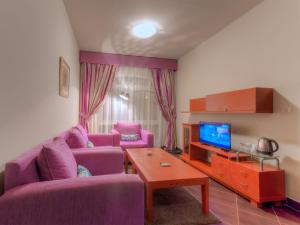 马特鲁港Porto Matrouh Apartments By Amer-Group的客厅配有两张紫色沙发和一台电视机