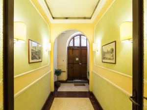 罗马马里迪当代套房酒店 的走廊上设有黄色的墙壁和木门