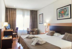 莱昂FC莱昂公主酒店的酒店客房设有两张床和电视。