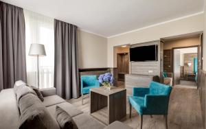 卡尔帕奇Hotel Konradówka Wellness & SPA - 300 metrów do centrum的客厅配有沙发和蓝色椅子