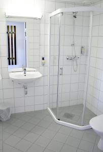 哈尔登Motell Svinesundparken的一间带玻璃淋浴和水槽的浴室