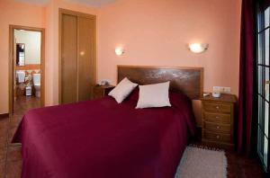 Cuesta de la Palma德尔波尼恩特田园酒店的一间卧室配有一张大床,提供紫色床单和枕头