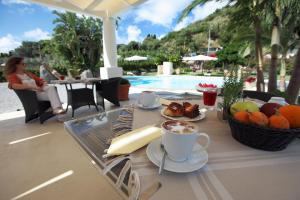 利帕里拉吉尔拉酒店的池畔餐桌旁的咖啡和水果