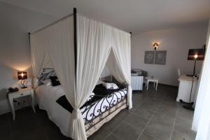 博尼法乔阿马多内塔酒店的一间卧室配有一张带天蓬的床