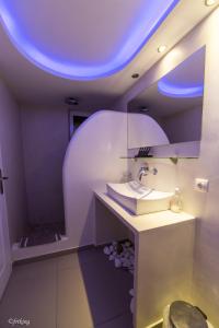 卡马利阿基里斯公寓酒店的一间带水槽和蓝色天花板的浴室