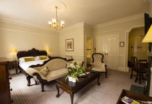 罗泽尔哈顿主教城堡酒店的一间卧室配有一张床、一张沙发和一张桌子