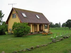 TreimaniTreimani Puhkemaja的一个小黄色房子,配有野餐桌和椅子