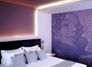 斯卡拉Tesoro Blu Hotel & Spa Adults Only的一间卧室配有一张紫色墙壁的床