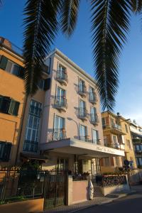 圣贝内代托-德尔特龙托公寓式酒店的前面有棕榈树的建筑