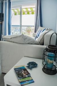 美洲海滩Apartment Las Americas的客厅配有一张沙发、一本书和一张桌子