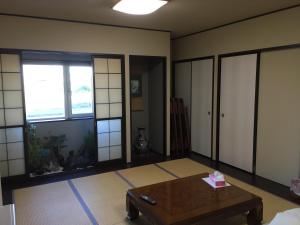 稚内山一日式旅馆的客厅配有咖啡桌和窗户