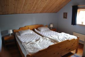 奥萨Orsastuguthyrning - Stenberg的一间卧室配有一张大木床和白色床单
