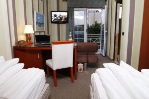 都拉斯贝奥康提酒店的客房设有一张桌子、一台电脑和一把椅子