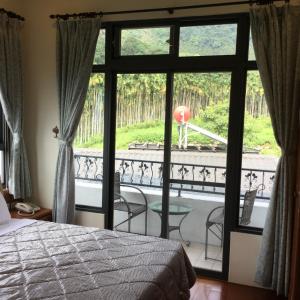 埔里闕麒景觀民宿Chill Villa B&B的一间卧室设有一张床,享有阳台的景色