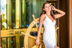 圣弗拉斯迪尼威滨海宫酒店的站在木轮旁的白色女装