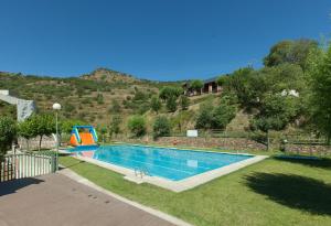 里亚尔普阿尔贝格莱斯埃斯塔德斯酒店的一个带滑梯的草地游泳池