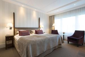 赫尔辛堡瑞典精英酒店的酒店客房带一张大床和一把椅子