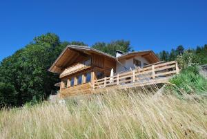 巴塞尔加·迪·皮纳Guest House Dolomiti的一块高大的草场上的木房子