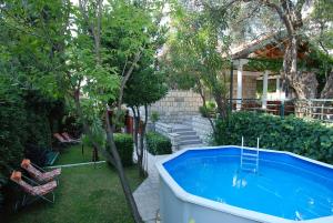 布德瓦Holiday Home Olive Tree的后院设有热水浴池和树