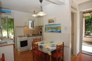 布德瓦Holiday Home Olive Tree的厨房配有桌子和桌椅