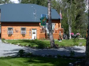 瓦西拉阿拉斯加湖露西尔食宿酒店的前面有一个美国国旗的小木屋
