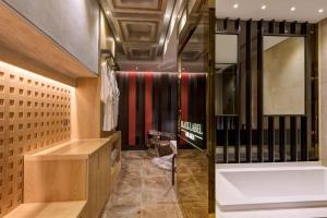 首尔空达设计师酒店的更衣室设有浴缸和镜子