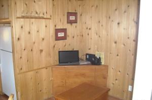 Harden Flat优胜美地湖群小屋40号假日公园的一间设有木墙的房间,配有一张书桌上的电脑