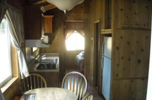 Harden Flat优胜美地湖群小屋39号假日公园的一间小房子里的厨房,配有桌椅