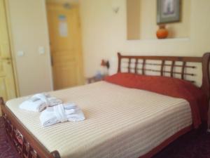 戛纳亚历山大三世酒店的一间卧室配有一张床,上面有两条毛巾