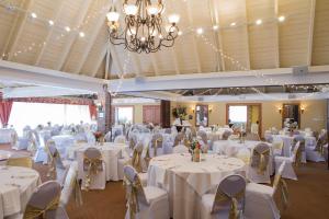 默特尔比奇帆船度假酒店的一个带白色桌椅的大型宴会厅