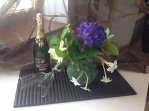 新阿丰Svetlana Guest House的一瓶香槟和一瓶花在桌子上